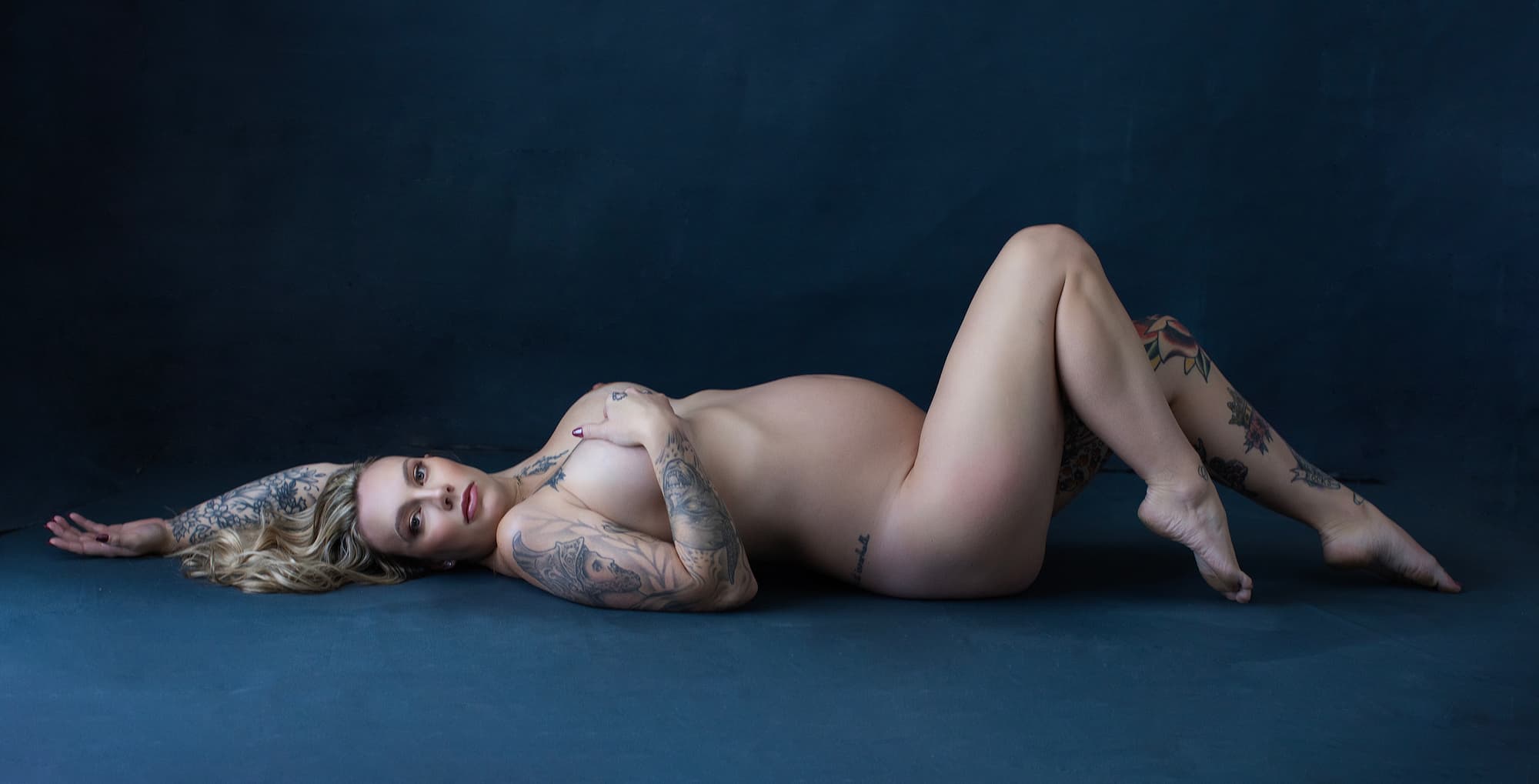 stunning pregnant woman lying on her back posing for a maternity shot