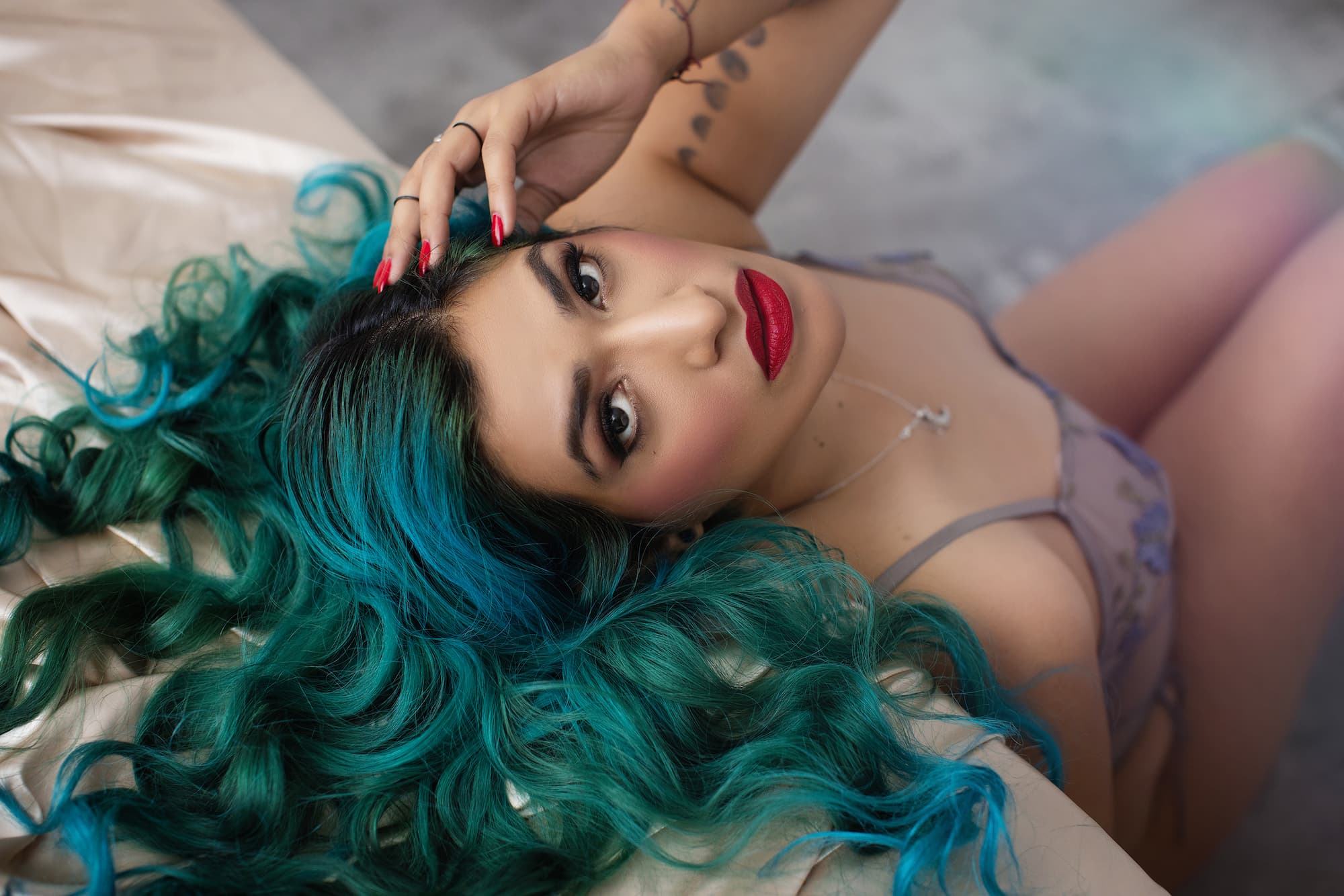 stunning blue haired woman posing gracefully for a boudoir shoot